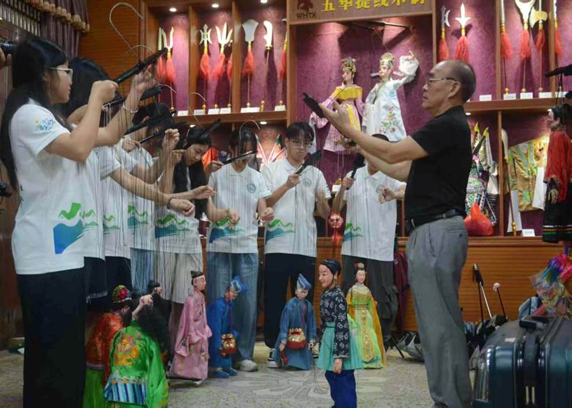 图1:国家级非遗传承人李新贤讲解提线木偶